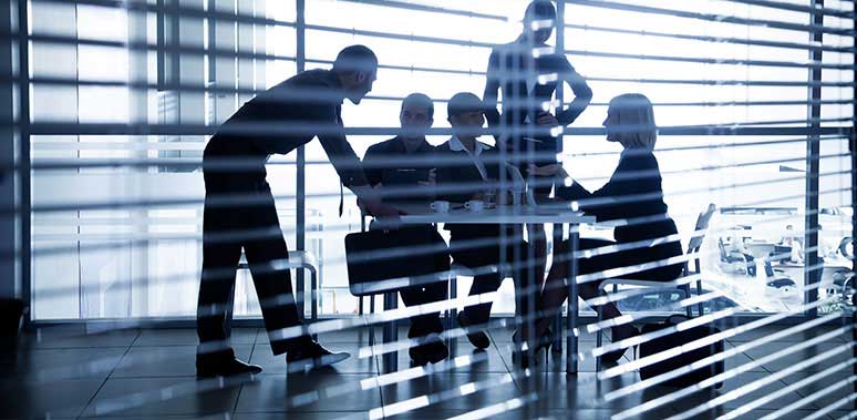 People Meeting At Table Behind Blinds Feature