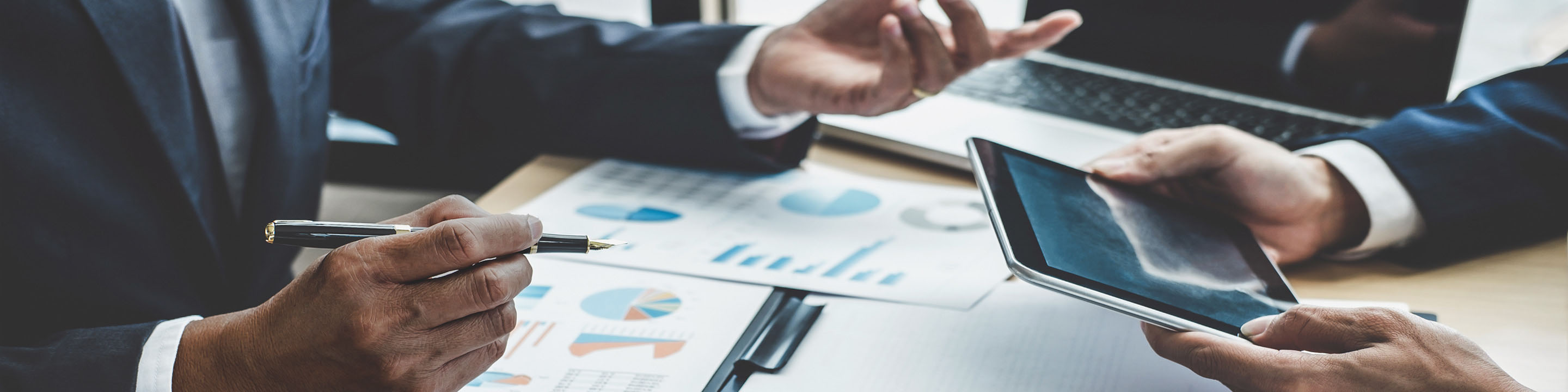 Navigate an IRS Business Audit With Confidence - Hands gesturing over papers with graphs and data.